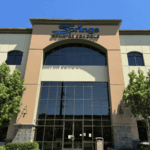 Front view of a Springs Charter Schools building with large windows, trees, and the school name displayed above the entrance.