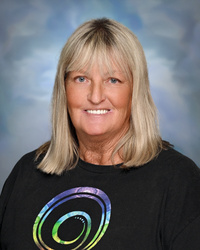 Portrait of staff member smiling against a studio background.