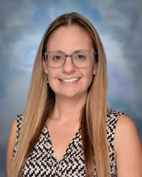 Portrait of staff member smiling against a studio background.