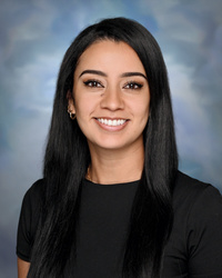 Portrait of staff member smiling against a studio background.