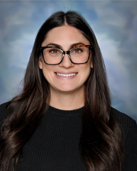 Portrait of staff member smiling against a studio background.