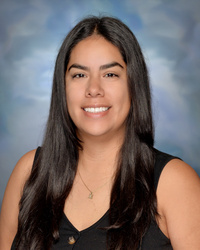 Portrait of staff member smiling against a studio background.