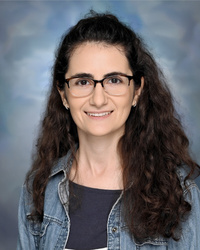 Portrait of staff member smiling against a studio background.