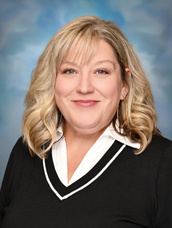 Portrait of staff member smiling against a studio background.