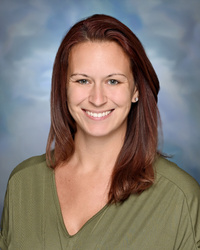 Portrait of staff member Ashley Arellano smiling against a studio background.