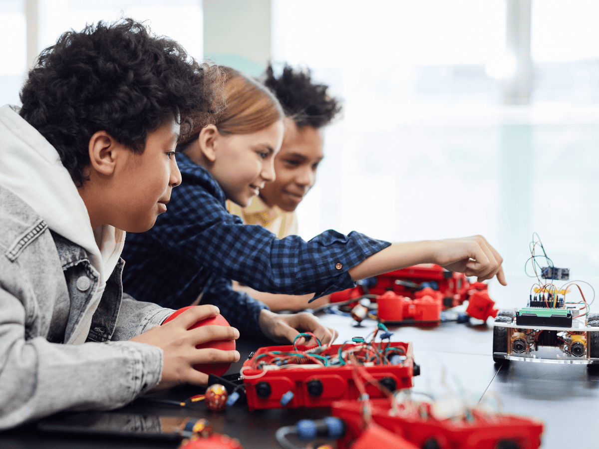 Students engaged in a hands-on STEM activity, working with robotics and electronic components.