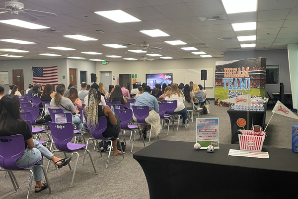 Parents and staff seated in a classroom watching the Parent Ignite Virtual Watch Party presentation on screen.