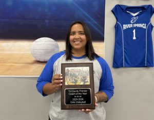 River Springs Charter Schools volleyball coach holding a plaque for Tri-County Premier Coach of the Year 2025–2026.