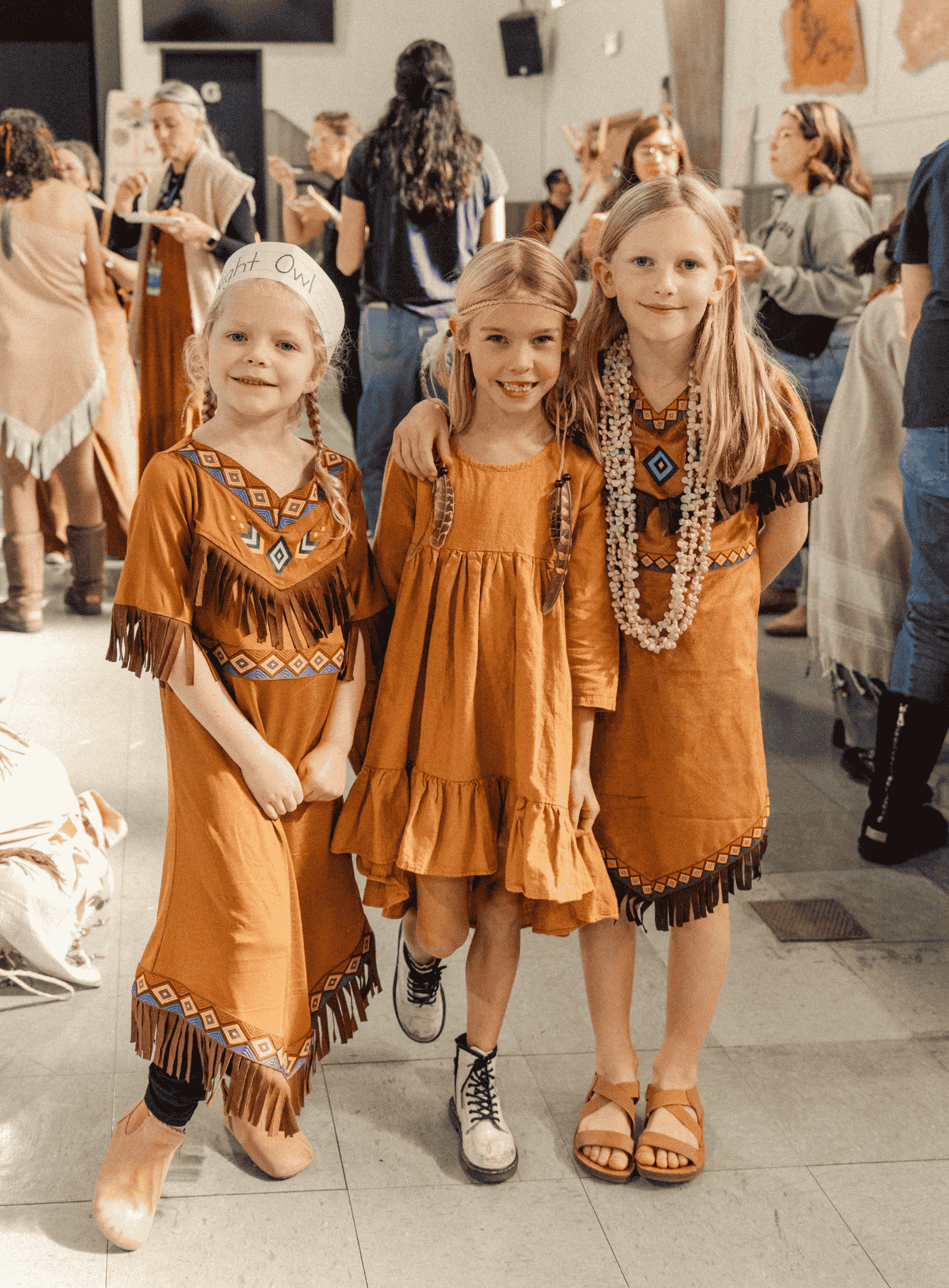Springs Charter Schools students wearing cultural outfits smile together at a school celebration.