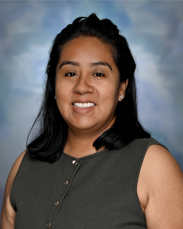 Professional headshot of a Springs Charter Schools staff member smiling against a neutral studio background.