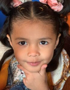 Springs Charter Schools student smiling confidently with hand under chin in a close-up portrait.