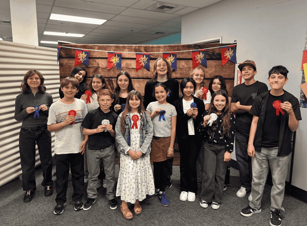 Springs Charter Schools students pose together holding award ribbons during a student recognition event.