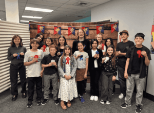 Springs Charter Schools students pose together holding award ribbons during a student recognition event.