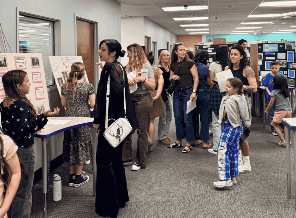 Families and students explore project displays during a Springs Charter Schools student expo event.