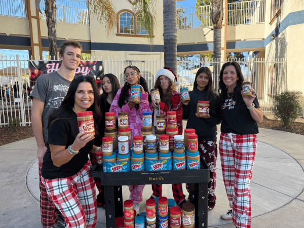Temecula Student Center staff and students at Springs Charter Schools participate in a peanut butter donation drive while wearing festive pajamas.