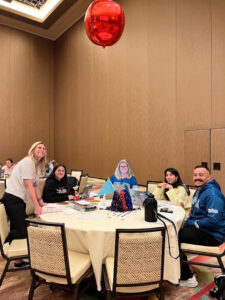 Springs Charter Schools educator holding a K–6 writing instruction resource during a professional development session.