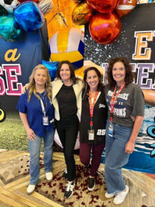 Springs Charter Schools staff members posing together at a professional learning summit event with themed decorations and balloons.