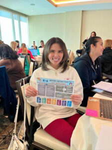 Springs Charter Schools educator holding a K–6 writing instruction resource during a professional development session.