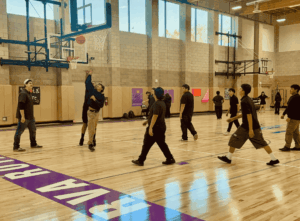 Students playing basketball during a physical education activity inside a Springs Charter Schools gymnasium.