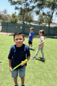 Young student participating in an outdoor activity on the grass during school enrichment time.