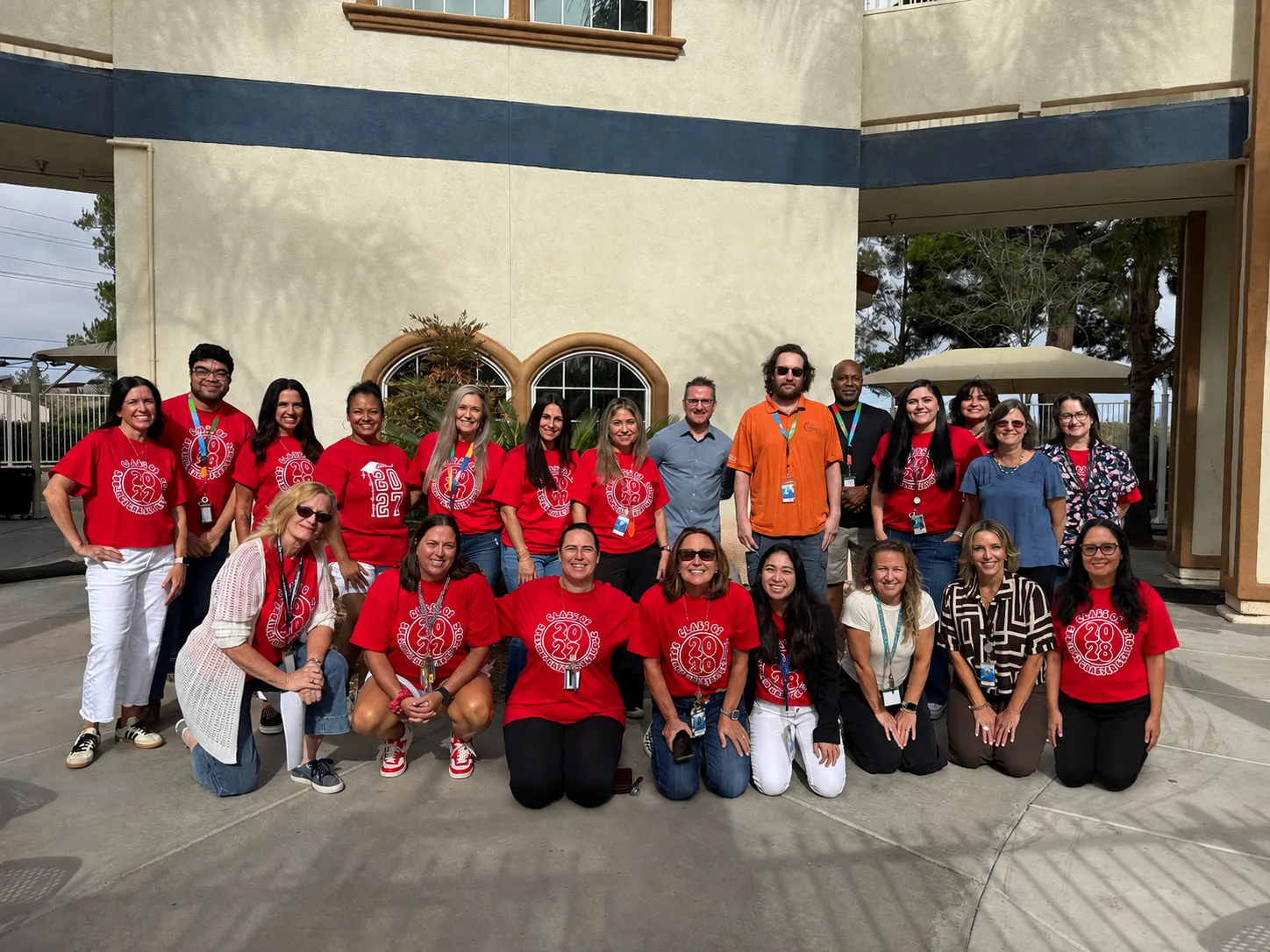 Temecula Student Center staff members posing together outdoors in front of a school building, with many wearing matching red shirts.